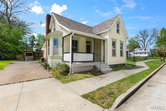 63 N Hanover St, Cape Girardeau, MO 63701 - view of front of property featuring covered porch, a shingled roof, a chimney, central AC, and fence