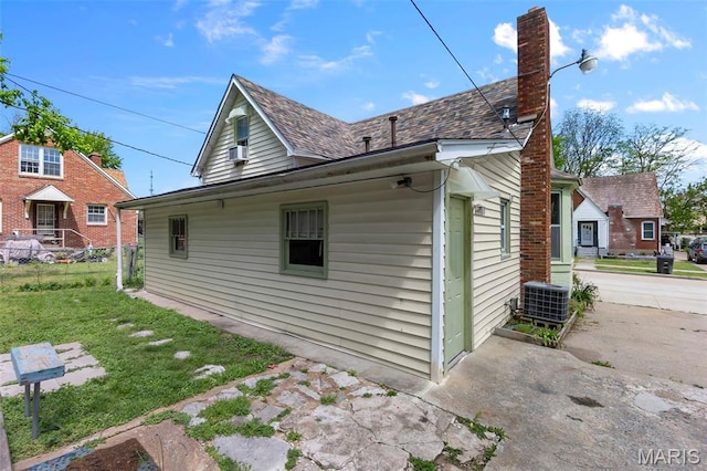 63 N Hanover St, Cape Girardeau, MO 63701 - view of property exterior with a chimney, central AC unit, and a lawn
