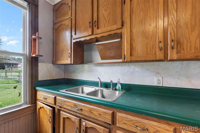 63 N Hanover St, Cape Girardeau, MO 63701 - kitchen featuring a sink, brown cabinets, decorative backsplash, and healthy amount of natural light