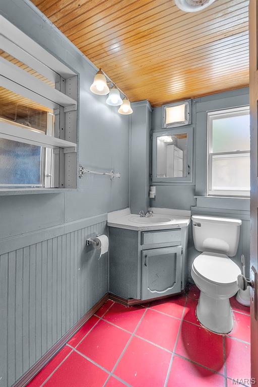 63 N Hanover St, Cape Girardeau, MO 63701 - half bath featuring wooden ceiling, toilet, vanity, wainscoting, and wood walls
