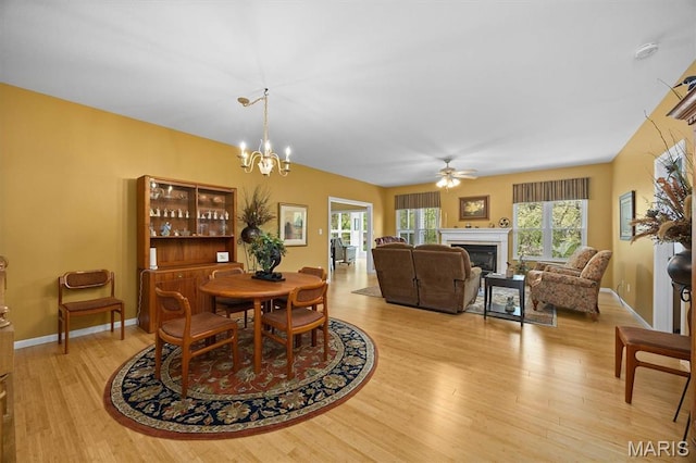 1674 Lakepointe Estates Dr, Ofallon, IL 62269 - dining area featuring light wood-style floors, a fireplace, plenty of natural light, and ceiling fan