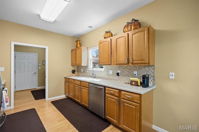 1674 Lakepointe Estates Dr, Ofallon, IL 62269 - kitchen with dishwasher, light wood-style flooring, decorative backsplash, light countertops, and brown cabinets