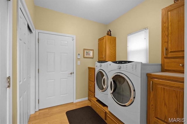 1674 Lakepointe Estates Dr, Ofallon, IL 62269 - washroom featuring washing machine and dryer, cabinet space, and light wood-style floors
