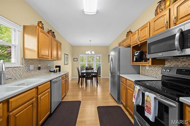 1674 Lakepointe Estates Dr, Ofallon, IL 62269 - kitchen with stainless steel appliances, a chandelier, light wood finished floors, light countertops, and backsplash