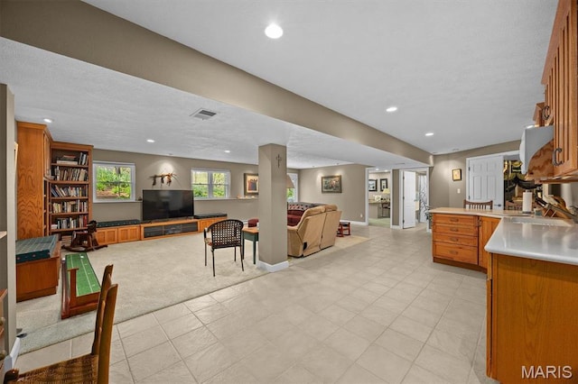 1674 Lakepointe Estates Dr, Ofallon, IL 62269 - kitchen with open floor plan, brown cabinets, a peninsula, a textured ceiling, and recessed lighting