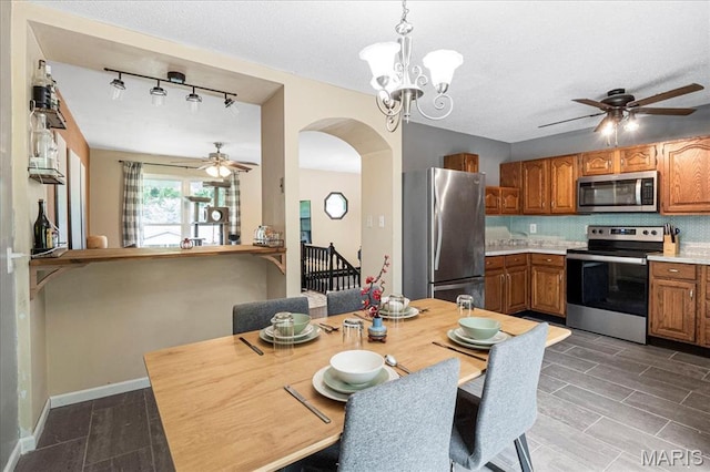 5553 Oak Pointe Dr, Imperial, MO 63052 - kitchen with appliances with stainless steel finishes, a ceiling fan, brown cabinets, arched walkways, and light countertops