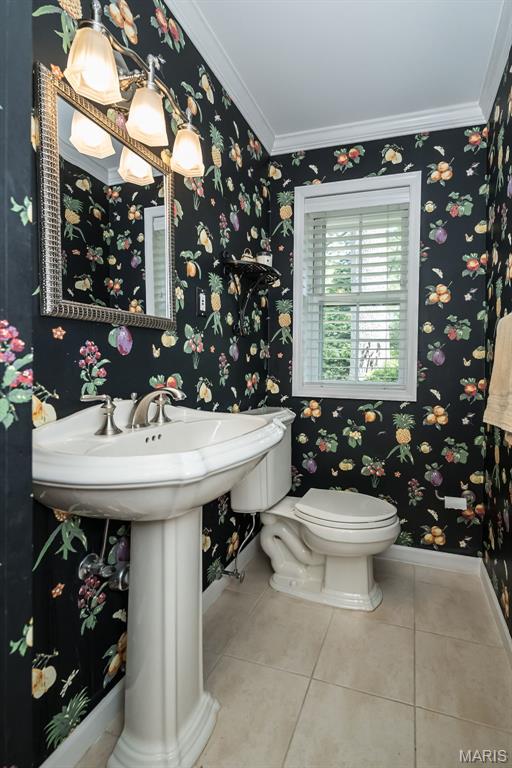 15 York Hills Dr, Saint Louis, MO 63144 - half bathroom featuring tile patterned flooring, toilet, ornamental molding, baseboards, and wallpapered walls