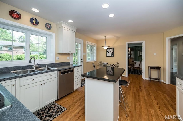 15 York Hills Dr, Saint Louis, MO 63144 - kitchen featuring a sink, stainless steel dishwasher, dark countertops, white cabinetry, and light wood-type flooring