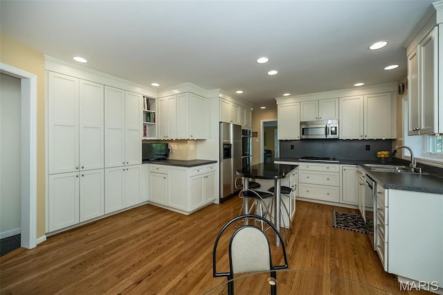 15 York Hills Dr, Saint Louis, MO 63144 - kitchen featuring appliances with stainless steel finishes, a sink, dark countertops, dark wood-style floors, and open shelves