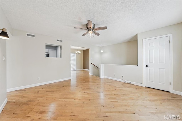 1521 Oriole Ln, Brentwood, MO 63144 - spare room featuring a ceiling fan, light wood-style flooring, a chandelier, a textured ceiling, and baseboards