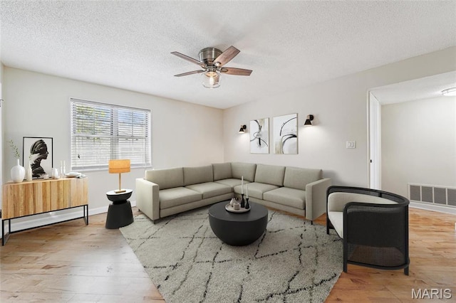 1521 Oriole Ln, Brentwood, MO 63144 - living room featuring a ceiling fan, a textured ceiling, wood finished floors, and baseboards