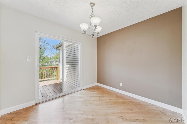 1521 Oriole Ln, Brentwood, MO 63144 - spare room featuring light wood-style flooring, a chandelier, baseboards, and a textured ceiling