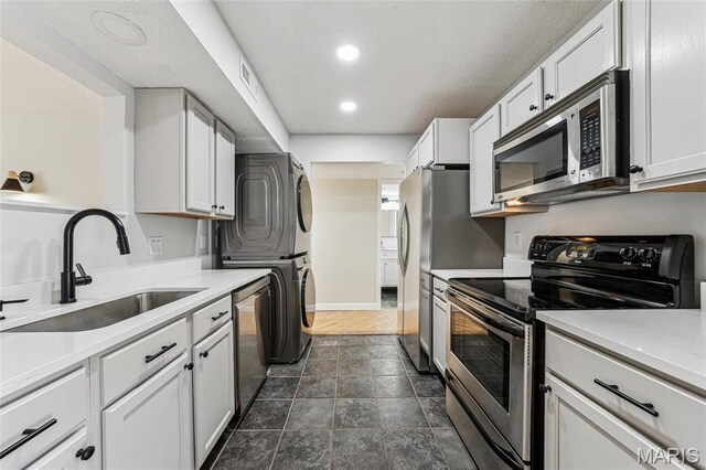 1521 Oriole Ln, Brentwood, MO 63144 - kitchen featuring appliances with stainless steel finishes, stacked washer and clothes dryer, a sink, light countertops, and recessed lighting