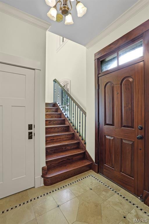 1201 Dolman St, Saint Louis, MO 63104 - tiled entryway with a chandelier, inlaid floor details, stairs, and ornamental molding