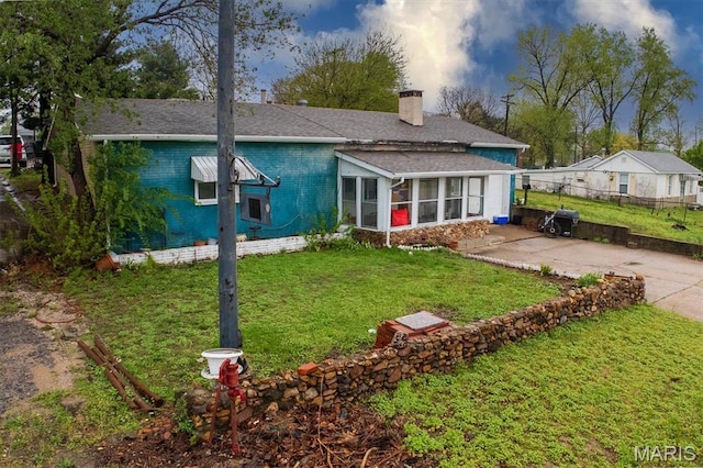 516 N Old Edwardsville Rd, Roxana, IL 62084 - back of house with a chimney, brick siding, and a sunroom