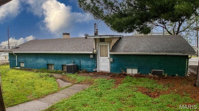516 N Old Edwardsville Rd, Roxana, IL 62084 - rear view of house featuring a chimney, central AC unit, roof with shingles, a yard, and brick siding