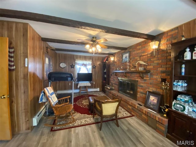 123 S Oak St, Nokomis, IL 62075 - living room featuring wooden walls, a baseboard radiator, a brick fireplace, beam ceiling, and wood finished floors