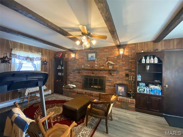 123 S Oak St, Nokomis, IL 62075 - living room with beam ceiling, wooden walls, wood finished floors, ceiling fan, and a fireplace