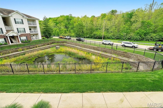 view of home's community featuring fence