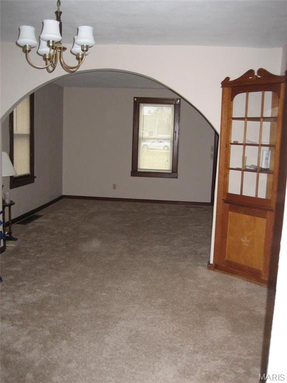 340 Kemper St, Troy, MO 63379 - unfurnished dining area with arched walkways, a chandelier, carpet, and baseboards