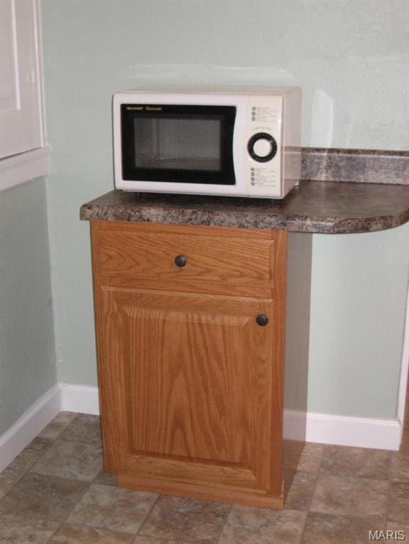 340 Kemper St, Troy, MO 63379 - kitchen view of white microwave, dark countertops, and baseboards