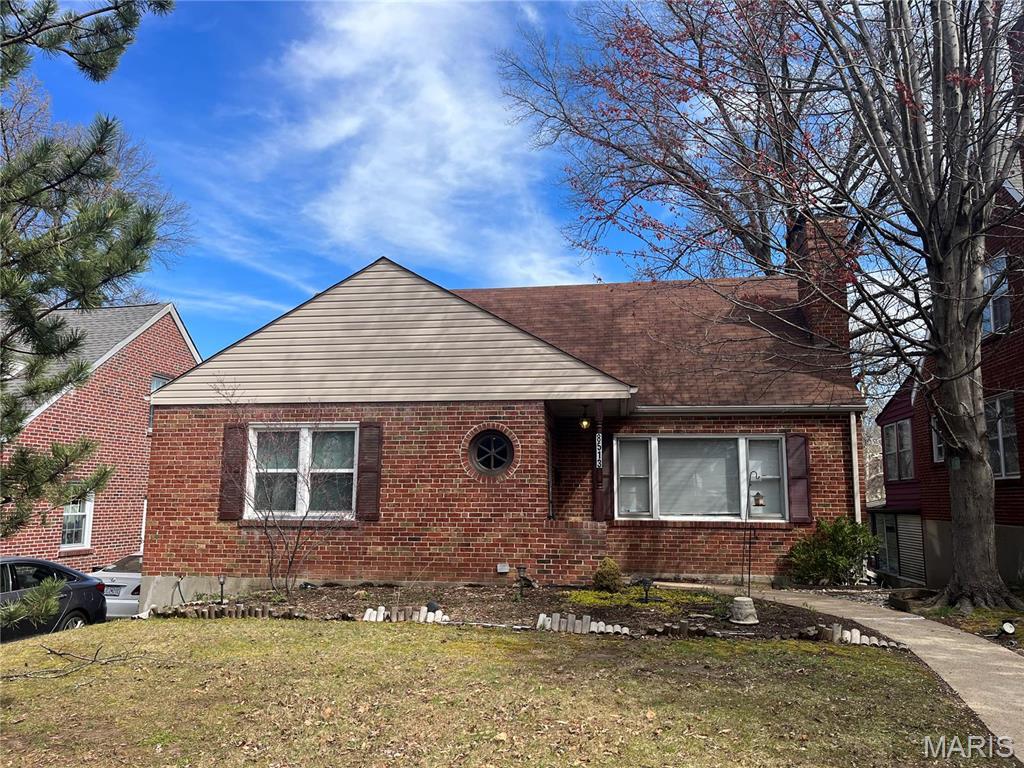 8513 Roanoke Dr, Saint Louis, MO 63121 - view of front facade featuring brick siding, a chimney, and a front yard