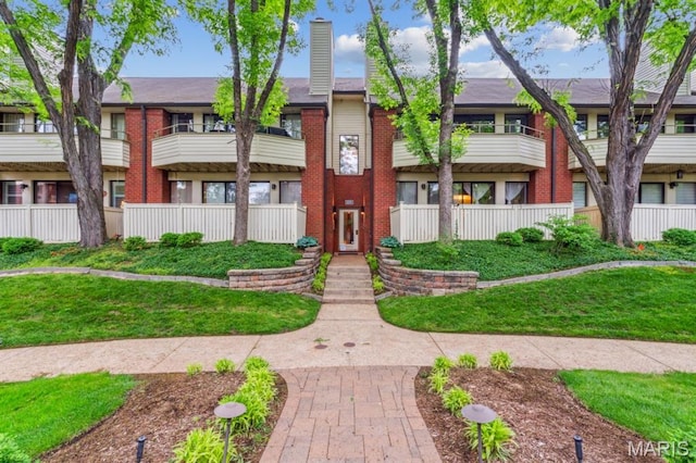 view of front of house featuring brick siding and a chimney