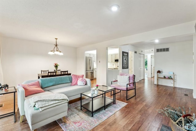 living area featuring hardwood / wood-style flooring, a chandelier, and recessed lighting