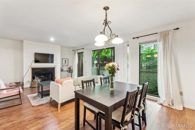 dining room with light wood-style floors, a fireplace, and recessed lighting