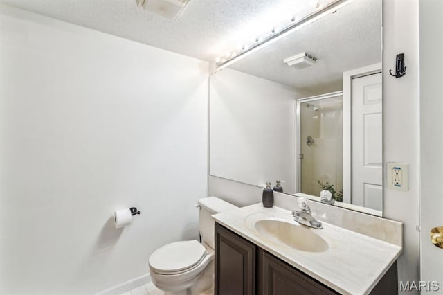 bathroom featuring a textured ceiling, a shower stall, toilet, vanity, and baseboards