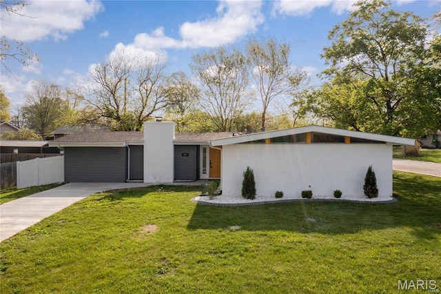 mid-century home featuring a chimney and driveway