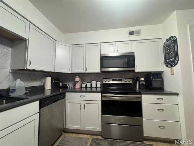 kitchen with appliances with stainless steel finishes, dark countertops, and decorative backsplash
