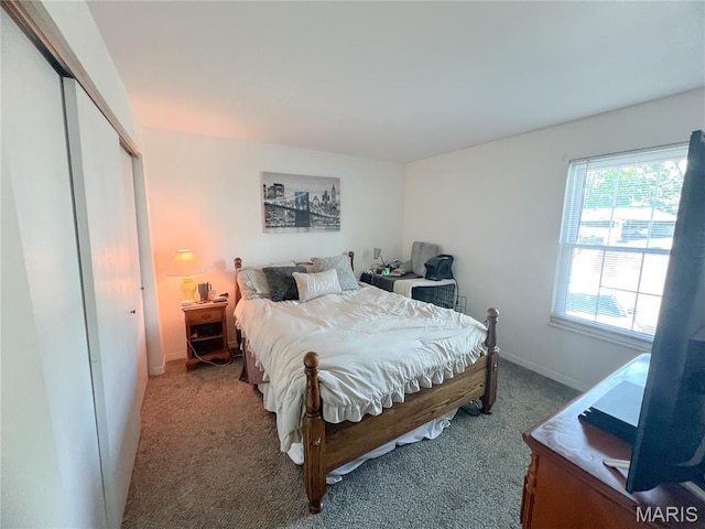 carpeted bedroom featuring a closet and baseboards