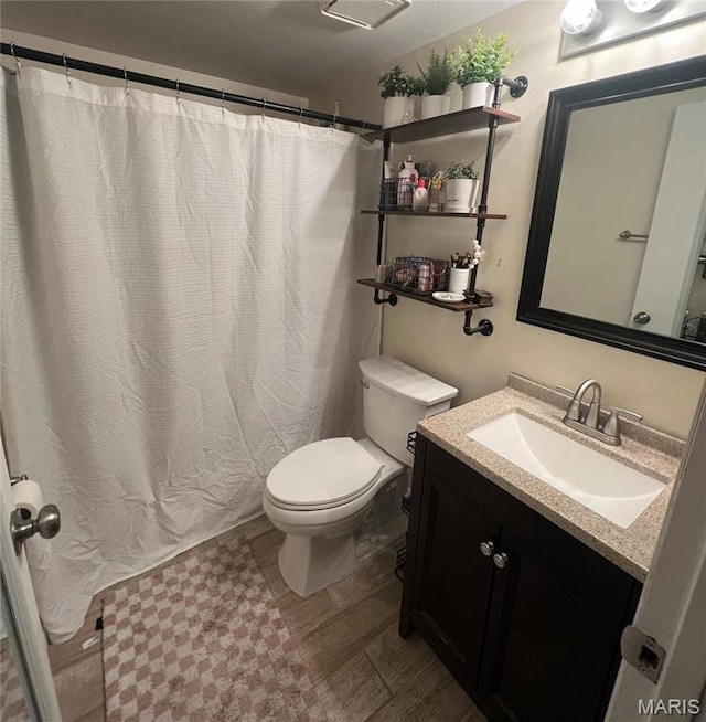full bathroom featuring toilet, wood finished floors, vanity, and curtained shower