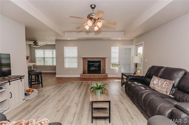 140 Vernon St, Saint Robert, MO 65584 - living area with a fireplace, a ceiling fan, light wood-type flooring, and a raised ceiling