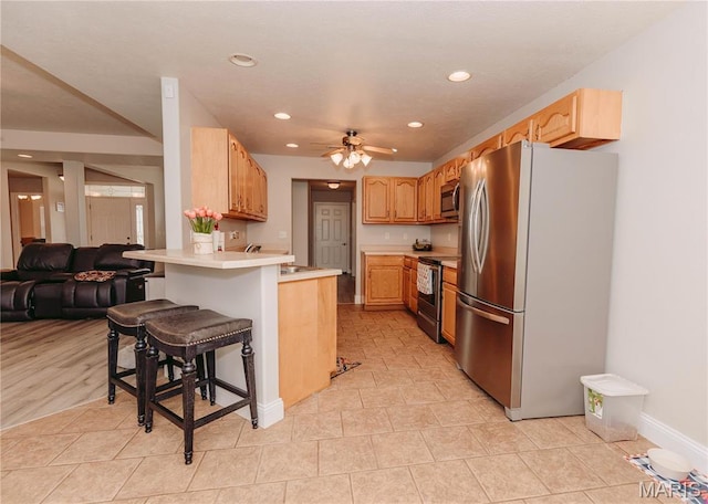 140 Vernon St, Saint Robert, MO 65584 - kitchen with stainless steel appliances, a peninsula, recessed lighting, a ceiling fan, and light countertops