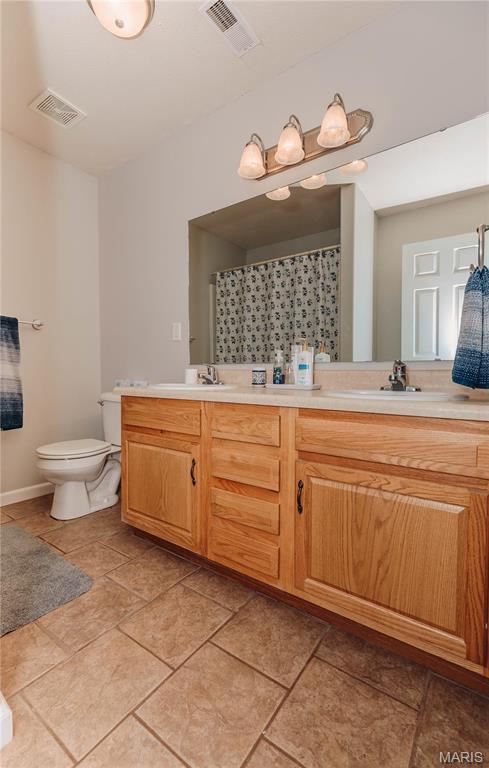 140 Vernon St, Saint Robert, MO 65584 - full bath featuring toilet, double vanity, and a shower with shower curtain