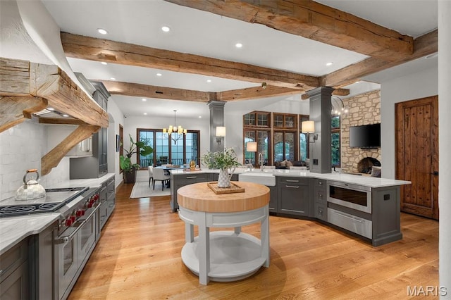 544 Quail Ridge Ln, Saint Albans, MO 63073 - kitchen with stainless steel appliances, ornate columns, recessed lighting, a peninsula, and a chandelier