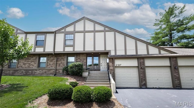 2317 Seven Pines Dr Unit 4, Saint Louis, MO 63146 - view of front of house featuring brick siding, a front yard, driveway, and stucco siding