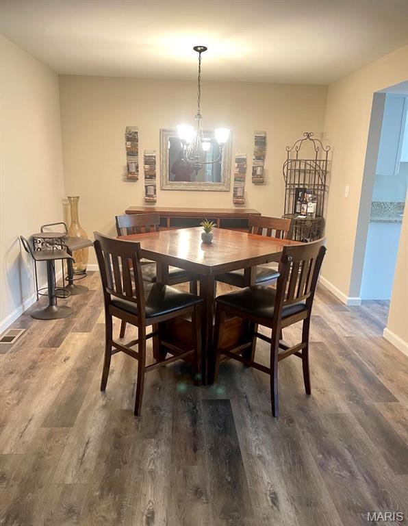 2317 Seven Pines Dr Unit 4, Saint Louis, MO 63146 - dining space with dark wood finished floors, a chandelier, and baseboards