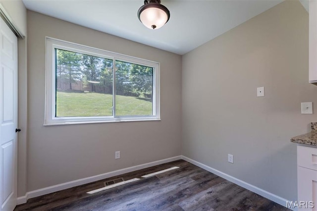 2317 Seven Pines Dr Unit 4, Saint Louis, MO 63146 - unfurnished dining area featuring dark wood-style flooring and baseboards