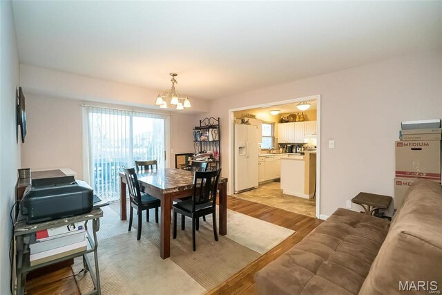 11518 Galba Dr, Florissant, MO 63033 - dining area with a chandelier and light wood-style floors