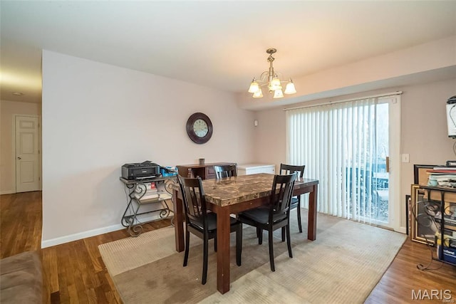 11518 Galba Dr, Florissant, MO 63033 - dining space featuring a chandelier, light wood finished floors, and baseboards