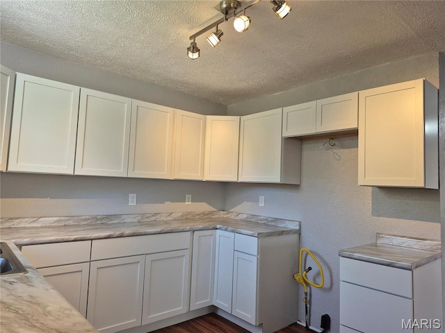 3308 Kendall Ave, Alton, IL 62002 - kitchen with a textured ceiling, white cabinets, light countertops, a sink, and rail lighting