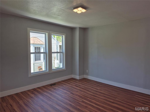 3308 Kendall Ave, Alton, IL 62002 - empty room featuring dark wood finished floors, baseboards, and a textured ceiling