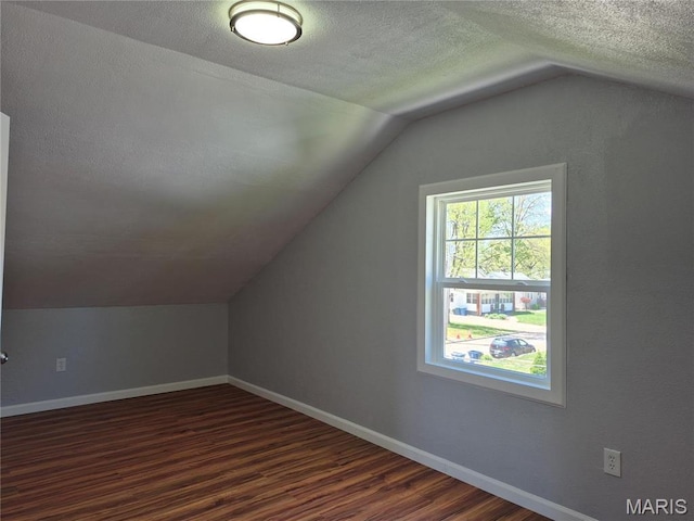 3308 Kendall Ave, Alton, IL 62002 - additional living space featuring vaulted ceiling, dark wood-type flooring, a textured ceiling, and baseboards