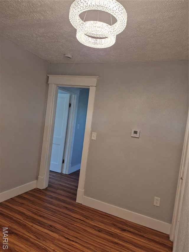 3308 Kendall Ave, Alton, IL 62002 - corridor featuring dark wood-type flooring, a chandelier, baseboards, and a textured ceiling