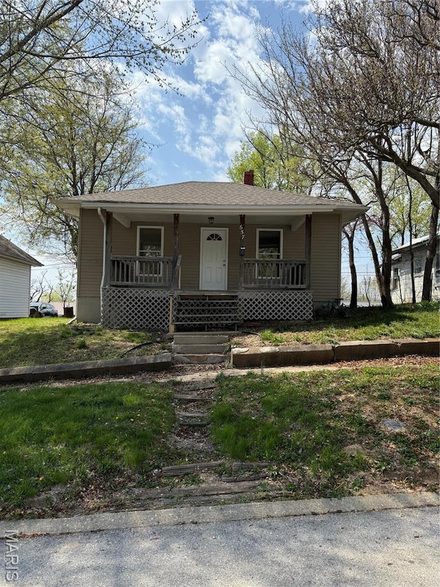 bungalow-style house with covered porch and a chimney