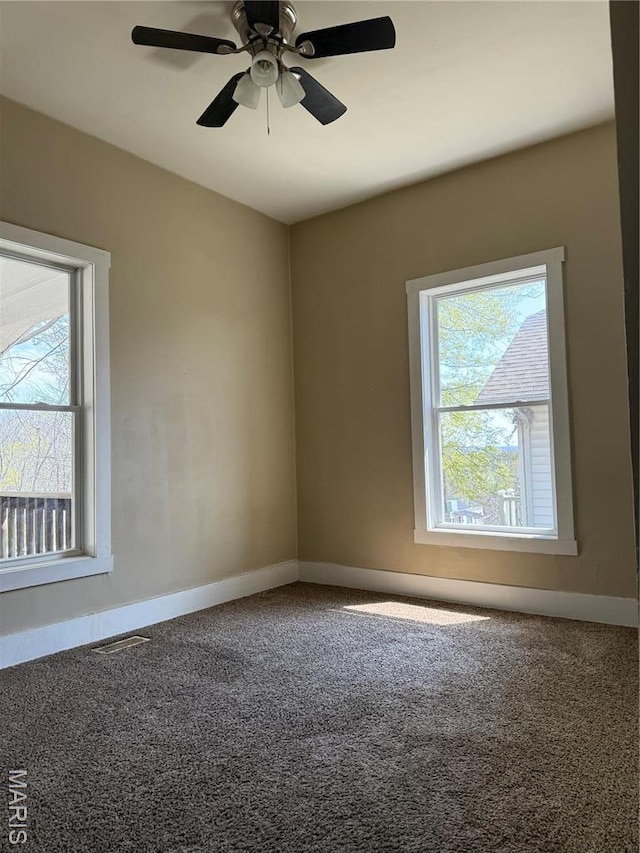spare room with healthy amount of natural light, carpet floors, and baseboards