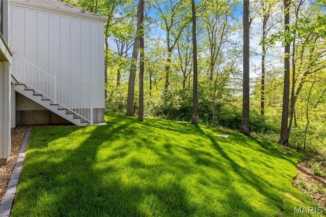 view of grassy yard with stairs